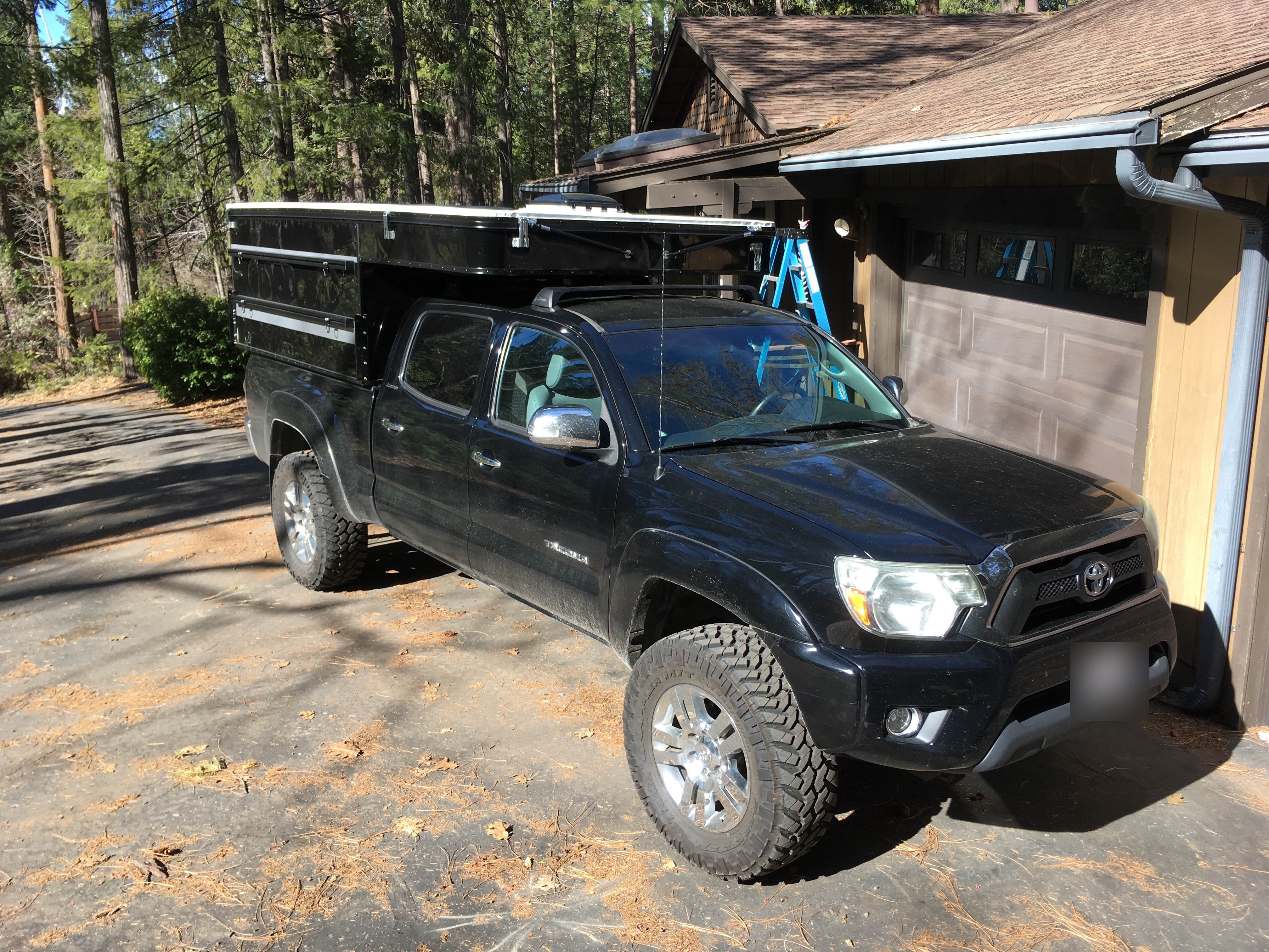 2013 Toyota Tacoma with Four Wheel Campers Project M - front three-quarter view showing lifted suspension and Nitto tires